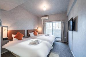 大阪市にあるApartment Hotel 11 Umedaの窓付きのホテルの部屋にベッドが2つある +22枚の写真