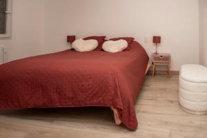 ein Schlafzimmer mit einem roten Bett mit zwei Kissen in der Unterkunft Cottage tout confort neuf au calme 6p WiFi in Chaumes en Retz