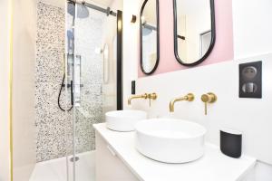 un bagno con due lavandini e una doccia di Charming and cosy flat next to the Eiffel Tower a Parigi