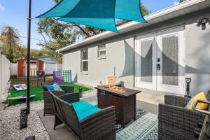 a patio with chairs and a table with an umbrella at Channel Side,Down Town Tampa ,Ybor Palmetto Beach with pickle ball court in Tampa