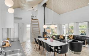 a kitchen and living room with a table and chairs at Stunning Home In Væggerløse With Wifi in Marielyst