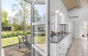 an open kitchen with a view of a garden at Stunning Home In Væggerløse With Wifi in Marielyst +23 photos