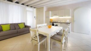 a kitchen and living room with a white table and chairs at Corte Elvira in Manerba del Garda