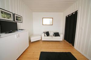 a living room with white furniture and a flat screen tv at Bergstaðastræti Apartment in Reykjavík