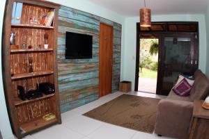 a living room with a wooden wall with a tv at Venere - Bed and Breakfast in Florianópolis