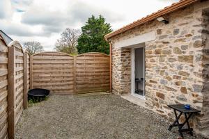 einen Holzzaun für Privatsphäre neben einem Haus in der Unterkunft Cottage tout confort neuf au calme 6p WiFi in Chaumes en Retz