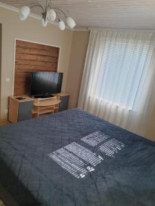 a bedroom with a bed and a flat screen tv at Kuressaare Centrum in Kuressaare