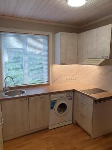 a kitchen with a sink and a washing machine at Kuressaare Centrum in Kuressaare