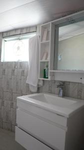 a white bathroom with a sink and a mirror at Apex Hotels and Resorts Phander Ghizer in Gologh Muli