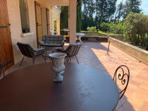 a table and chairs sitting on a patio at Villa CHATEAU SAINTE BARBE in Loriol-du-Comtat