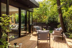 a deck with chairs and tables on a house at The Wooden House, Spacious, garden, new and modern in Oslo