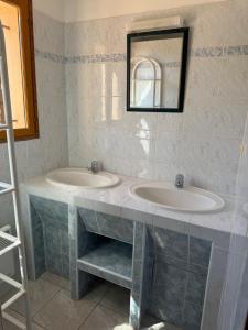 a bathroom with two sinks and a mirror at Altagna in Olmeto