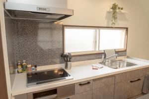 a kitchen with a sink and a counter top at New 充実設備&コスパ&快適重視の宿!空港美瑛富良野スキー場4ヵ所アクセス良!キッズエリア大人気 in Asahikawa