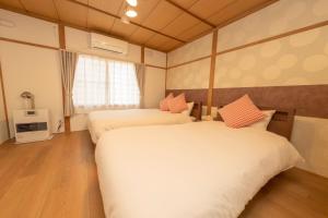 a hotel room with two beds and a window at New 充実設備&コスパ&快適重視の宿!空港美瑛富良野スキー場4ヵ所アクセス良!キッズエリア大人気 in Asahikawa