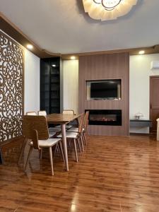 una sala da pranzo con tavolo, sedie e camino di Guest House Inn Side a Kobuleti
