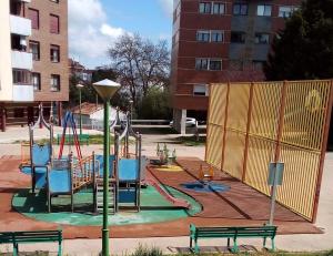 a park with a playground with a slide and benches at Apartamento Deluxe city in Burgos
