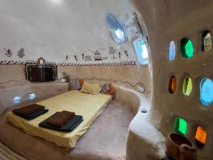 ein Schlafzimmer mit einem Bett in einem Zimmer mit Fenstern in der Unterkunft Mrudaranya the Earth Tech Pod in Panchgani