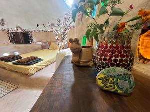 Zimmer mit 2 Betten und einem Tisch mit Vase in der Unterkunft Mrudaranya the Earth Tech Pod in Panchgani