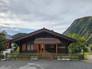 una pequeña casa con una valla delante de ella en Chalet Schönblick, en Blatten bei Naters