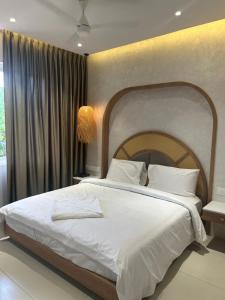 a bedroom with a large bed with white sheets and pillows at Three Oceans Resort in Kanyakumari +19 photos