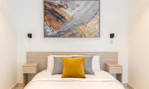 una almohada amarilla en una cama con un cuadro encima en Awesome 2 bedroom Space Available, en Accra