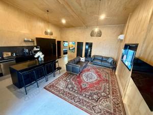 a living room with a couch and a rug at The Mango Shed in Mangakino