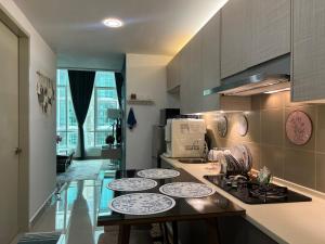 a kitchen with a counter with plates on it at Myra Guesthouse Bohemian Style Mutiara Ville Duplex Apartment in Cyberjaya
