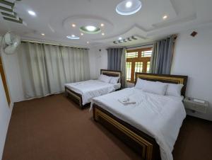 锡卡都Comfort Hotel & Huts的酒店房间有两张床，床单是白色的