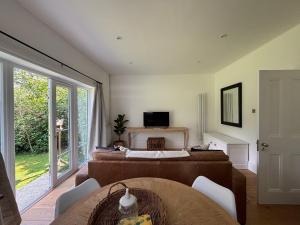 a bedroom with a bed and a table and a television at Aeolian House in Cranleigh