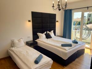 a bedroom with two beds with blue towels on them at Holiday Apartment ORA in Balchik