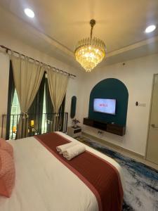 a bedroom with a large bed and a flat screen tv at Myra Guesthouse Bohemian Style Mutiara Ville Duplex Apartment in Cyberjaya