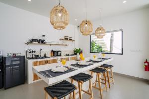 a kitchen with a long island with chairs and a table at Villa Alveena in Tumbak Bayuh in Tumbak Bayuh