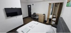 a room with a bed and a tv and a desk at HOTEL Vitan273 in Bucharest