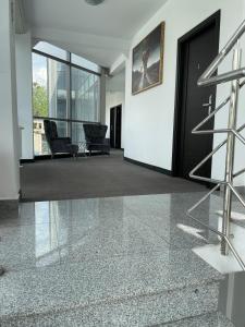 an empty lobby with a black door and a chair at HOTEL Vitan273 in Bucharest +12 photos