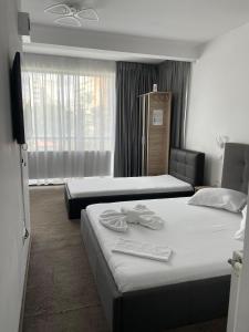 ブカレストにあるHOTEL Vitan273のベッドが2つと窓があるホテルの部屋