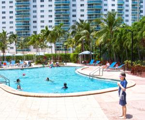 un niño parado en una piscina en un complejo en Ocean Reserve Luxury Condos Across from Sunny Isles Beach en Miami Beach