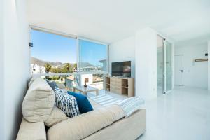 Una sala de estar con un sofá y una ventana grande. en La Plaza, en Puerto Pollensa