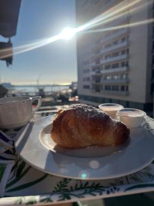 a pastry on a plate on a table with a view of a city at Porta Amari B&B in Palermo