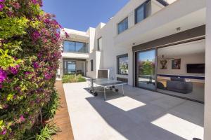 an exterior view of a house with a table and flowers at Villa JoJo Seafront in Ayia Napa