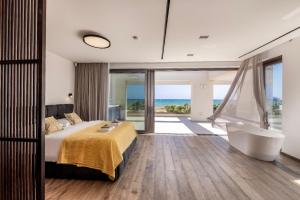 a bedroom with a bed and a tub and a view of the ocean at Villa JoJo Seafront in Ayia Napa +52 photos
