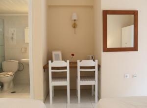 a bathroom with a table and two white chairs at Kathys Island Retreat in Adia +88 photos