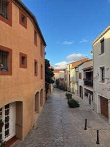 un vicolo vuoto in una città con edifici di Maison Soleil - Elne a Elne