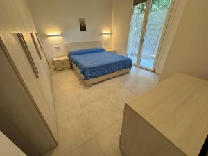 Un dormitorio con una cama con un edredón azul. en App4rent - Villa Cristina 10 - RINNOVATO, en Lido di Jesolo