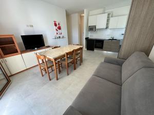 Una sala de estar con una mesa y sillas y un sofá. en App4rent - Villa Cristina 10 - RINNOVATO, en Lido di Jesolo