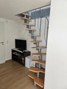 escalera de caracol en una sala de estar con TV en Ferienwohnung Hanna, en Stockach