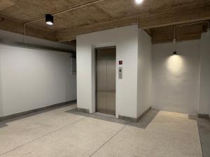 an empty room with a hallway with a elevator at Hometown Stays Hatyai in Hat Yai