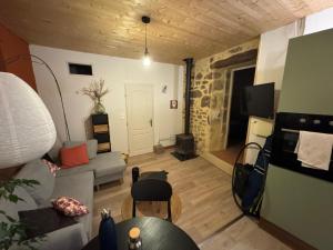 a living room with a couch and a tv at la ferme de la chanvriole in Mercuer