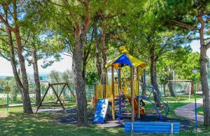 a playground in a park with trees at Camping Park delle Rose in Lazise