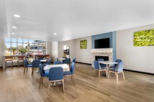 a waiting room with tables and chairs and a fireplace at Park Inn by Radisson in San Antonio