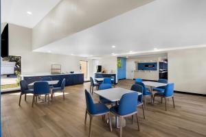 a cafeteria with tables and chairs and a kitchen at Park Inn by Radisson in San Antonio